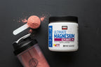 Flat lay of supplement powder scoop and shaker bottle on slate surface fitness aesthetic