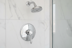Grohe Fairborn polished chrome shower trim set in minimalist spa bathroom with white marble tile and refreshing water stream from chrome shower head