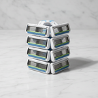 Stack of eight modern white and silver razor cartridges on clean marble surface