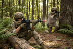 Teenagers in tactical gear playing airsoft in wooded setting with Game Face Elite Renegade military-style spring-powered airsoft rifle — 350 FPS 6mm BB airsoft action