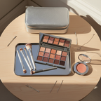 Lifestyle image - elegant vanity flatlay with silver makeup organizer case and beauty palettes, editorial styling for visual context only