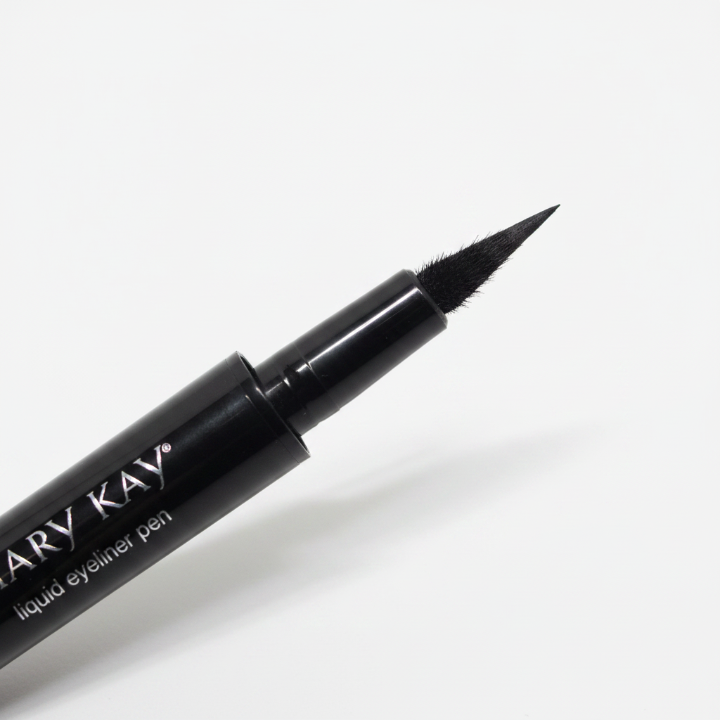 Close-up macro of Mary Kay Liquid Eyeliner Pen MK Black showing the ultra-fine flexible felt-tip applicator nib in sharp detail on a clean white background with soft diffused lighting