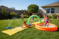 Wham-O Slip N Slide Water Park set up on backyard lawn kids sliding splashing