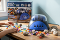 Maxx Explore Rock Tumbler blue machine on wooden desk with colorful polished gemstones and rough rocks