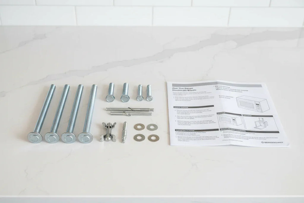 Microwave mounting hardware and bolts laid out beside installation instructions in modern kitchen