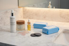 Minimalist evening skincare routine on marble counter featuring Rodan + Fields eye cloths among beauty essentials