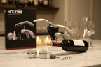 Houdini Lever Corkscrew by Rabbit pulling cork from dark green wine bottle on marble countertop with silver ball stoppers and extra spiral nearby - More4less Outlet