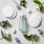 Elegant flat lay of a skincare serum bottle with cotton pads and botanicals on white marble