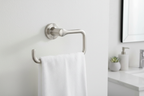 Brushed nickel towel ring mounted on a white textured wall in a minimalist modern bathroom