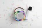 Flat lay of Bytech Mini Karaoke Speaker and wireless microphone on white surface with colorful confetti accents