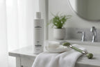 Jan Marini C-ESTA Cleansing Gel on marble vanity with cotton rounds and jade roller lifestyle