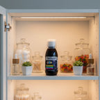 Sambucol Kids Black Elderberry Syrup 4oz bottle inside organized medicine cabinet with high-transparency apothecary containers and soft interior recessed lighting