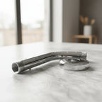 Close up of pristine Hansgrohe polished chrome shower arm hardware catching bright natural daylight