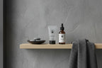 Minimalist bathroom shelf showcasing Duke Cannon men's grooming kit essentials against grey slate