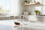Two Riedel stemless crystal wine tumblers sunlight modern kitchen white marble one with red wine — More4less Outlet
