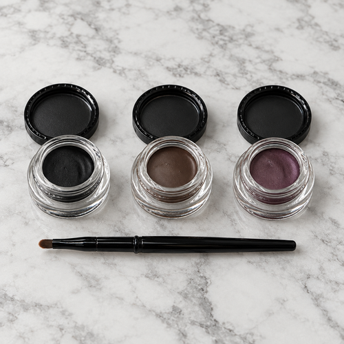Mary Kay Gel Eyeliner in Jet Black, Espresso Ink and Ornate Orchid with brush on a marble vanity