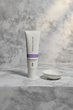 Rodan and Fields UNBLEMISH Invisible Matte Defense SPF 30 tube on a light grey stone surface with soft morning light and white ceramic dish – More4less Outlet