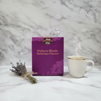 Purple Yogi Wellness Blends tea gift box closed on a white marble surface next to dried lavender and a ceramic mug, elegant gift presentation.