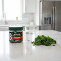 8Greens Daily Greens Peach Gummies jar on white quartz breakfast island with glass of water and fresh kale leaves