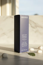 Morning sunlight hitting a deep blue luxury face mask box on a white marble surface