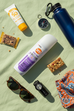 OFF! Clean Feel Insect Repellent flat lay on green background with sunscreen compass and water bottle