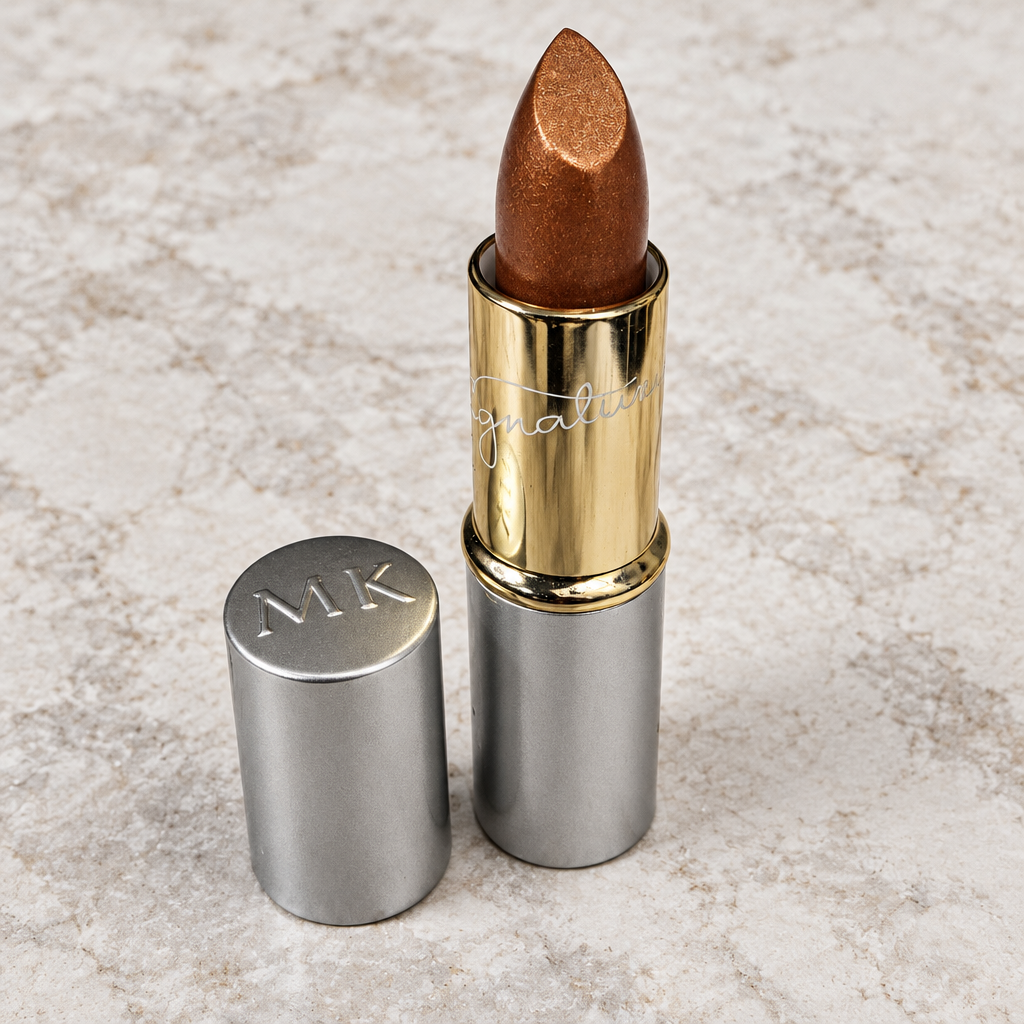 Close detail of Mary Kay Gold Dust metallic lipstick with silver cap