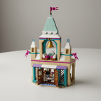 LEGO Disney Frozen Arendelle Frozen Castle set 43265 close-up showing opening front doors revealing dining room interior, upper bedroom with movable beds and drawers, and golden bell at top of teal tower