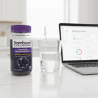 Sambucol Black Elderberry Gummies bottle on white quartz kitchen island with glass of water and open laptop for work-day wellness