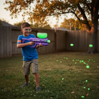 Child holding purple Gel Blaster Starfire toy blaster outdoors dusk safety goggles glow-in-the-dark green gellets hopper backyard active play - More4less Outlet