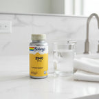 Solaray Zinc 50mg bottle on white quartz bathroom vanity with glass of water and white cotton hand towel