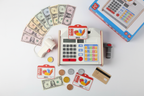 Hape Beep n Buy Cash Register full 24-piece set overhead flatlay with play money scanner and shopping cards - More4less Outlet