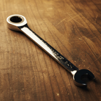 Close-up of GEARWRENCH 1-1/4 inch ratcheting combination wrench box and open ends on a wooden workbench
