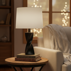 Cozy interior vignette with warm ambient lighting from a sculpted matte black twisted lamp base on a side table