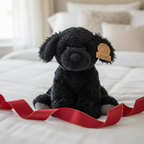 Animal Adventure Black Puppy Plush displayed as gift on white bedding with ribbon - More4less Outlet