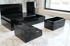 Macro shot of Officemate black stationery holder catching window light on white marble surface