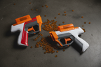 Two Nerf Pro Gelfire blasters resting on dark concrete surface with scattered orange hydrated gel rounds