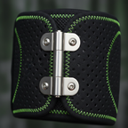 Macro close-up of bilateral metal hinge and perforated neoprene texture on black knee brace with green stitching