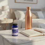 Motherlove Morning Sickness Blend bottle on marble bedside table with open wellness journal and copper water bottle
