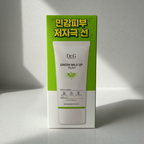 AI-generated lifestyle image of Dr.G Green Mild Up Sun+ SPF50+ PA++++ 70 mL retail box on a pale stone bathroom counter