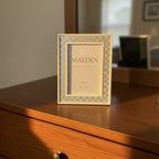 Close-up of Malden silver glitter diamond pattern picture frame in warm evening light on natural wood dresser