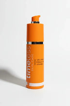 Detailed studio lighting highlighting an orange Vitamin C facial serum bottle with silver pump on white background