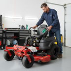 Man performing zero-turn mower maintenance in garage holding Kohler Genuine Parts Air Filter with green foam pre-cleaner