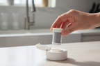 Contigo Clybourn replacement filter cartridge being inserted into water bottle lid on kitchen counter