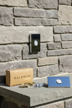 Baldwin Contemporary Doorbell Button Chrome on rustic slate stone patio wall