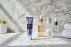 Bausch + Lomb LUMIFY Eye Illuminations Brightening Eye Cream on a modern white marble bathroom vanity with facial serums in bright morning light