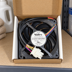 GE WR60X10358 condenser fan in its open box on a utility shelf