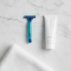 Gillette Sensor2 Plus blue razor on marble bathroom counter with shaving cream tube and white towel – More4less Outlet