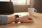 Person wearing rose gold stainless steel mesh smartwatch band at office desk with laptop and coffee – professional lifestyle photo