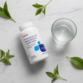 GNC Potassium & Magnesium Aspartate bottle on marble with green leaves and water – More4less Outlet