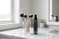 Clean vanity setup with makeup brushes and professional brush cleaning spray bottle on marble surface